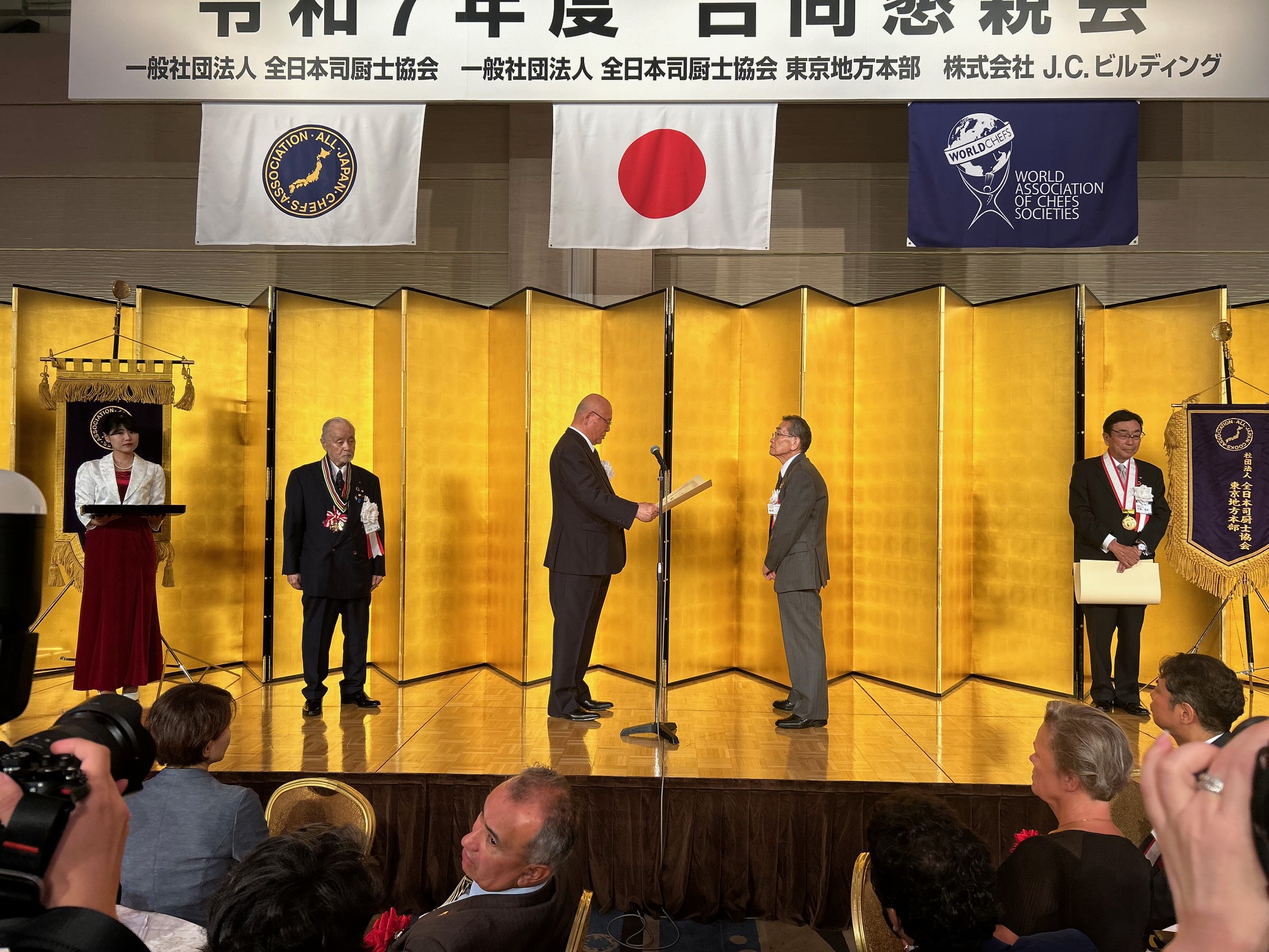表章を受ける飯塚隆氏
