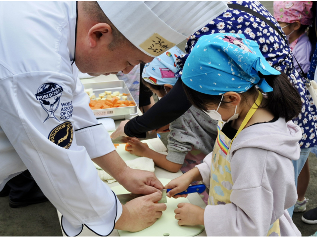 織田調理師専門学校　甲州教授が子供たちへ野菜の切り方を。